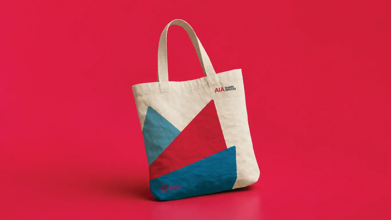 Canvas tote bag printed with the AIA Shared Services logo and red and blue mountain motif