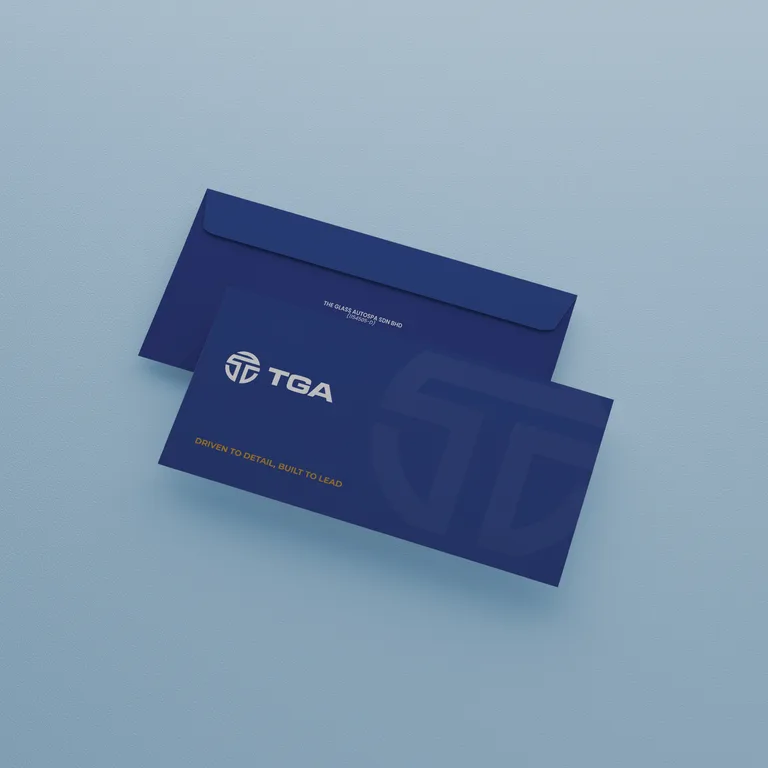 Two navy envelopes for TGA carrying the logomark and gold tagline on a pale blue surface